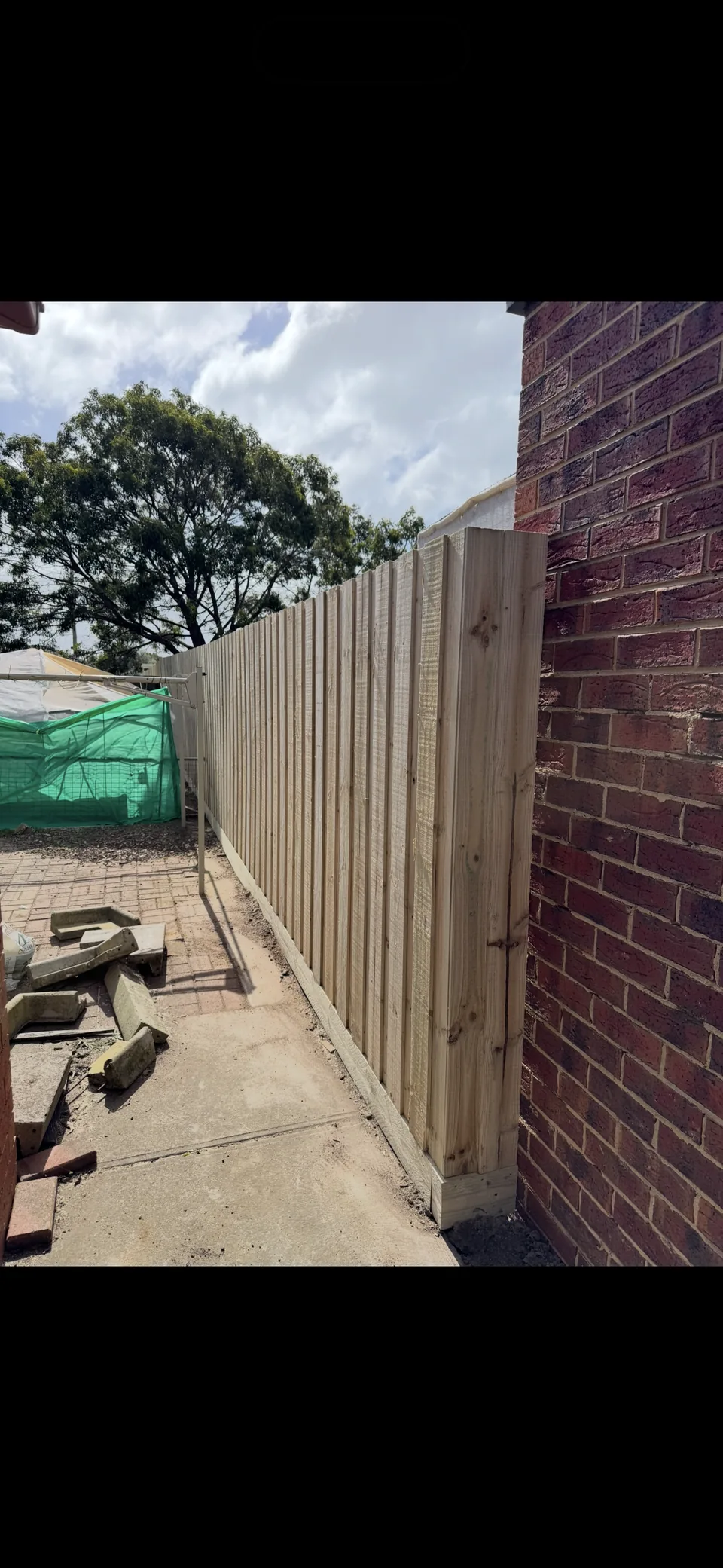 1.95 m timber paling fence beside a brick wall