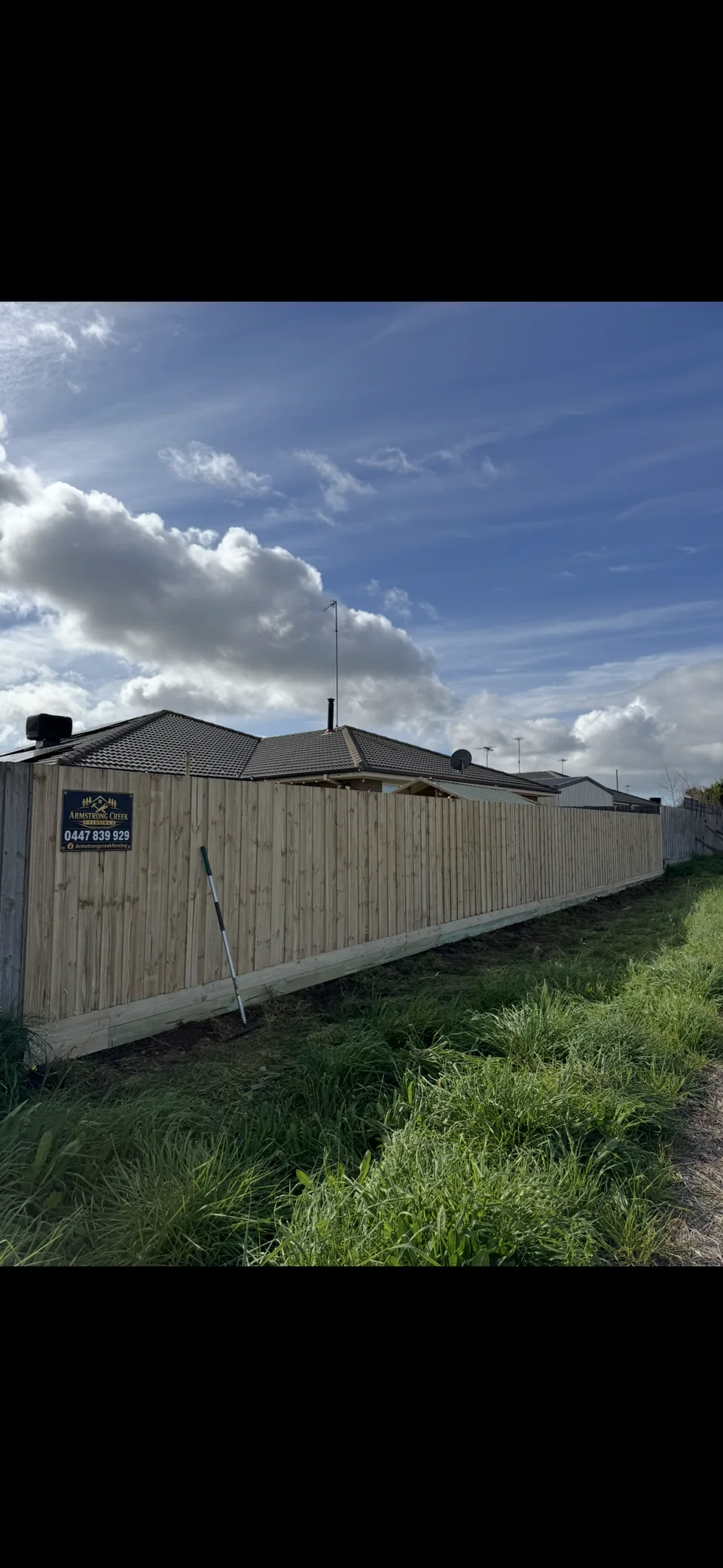 1.95 m paling fence with double plinth boards displaying an Armstrong Creek Fencing sign