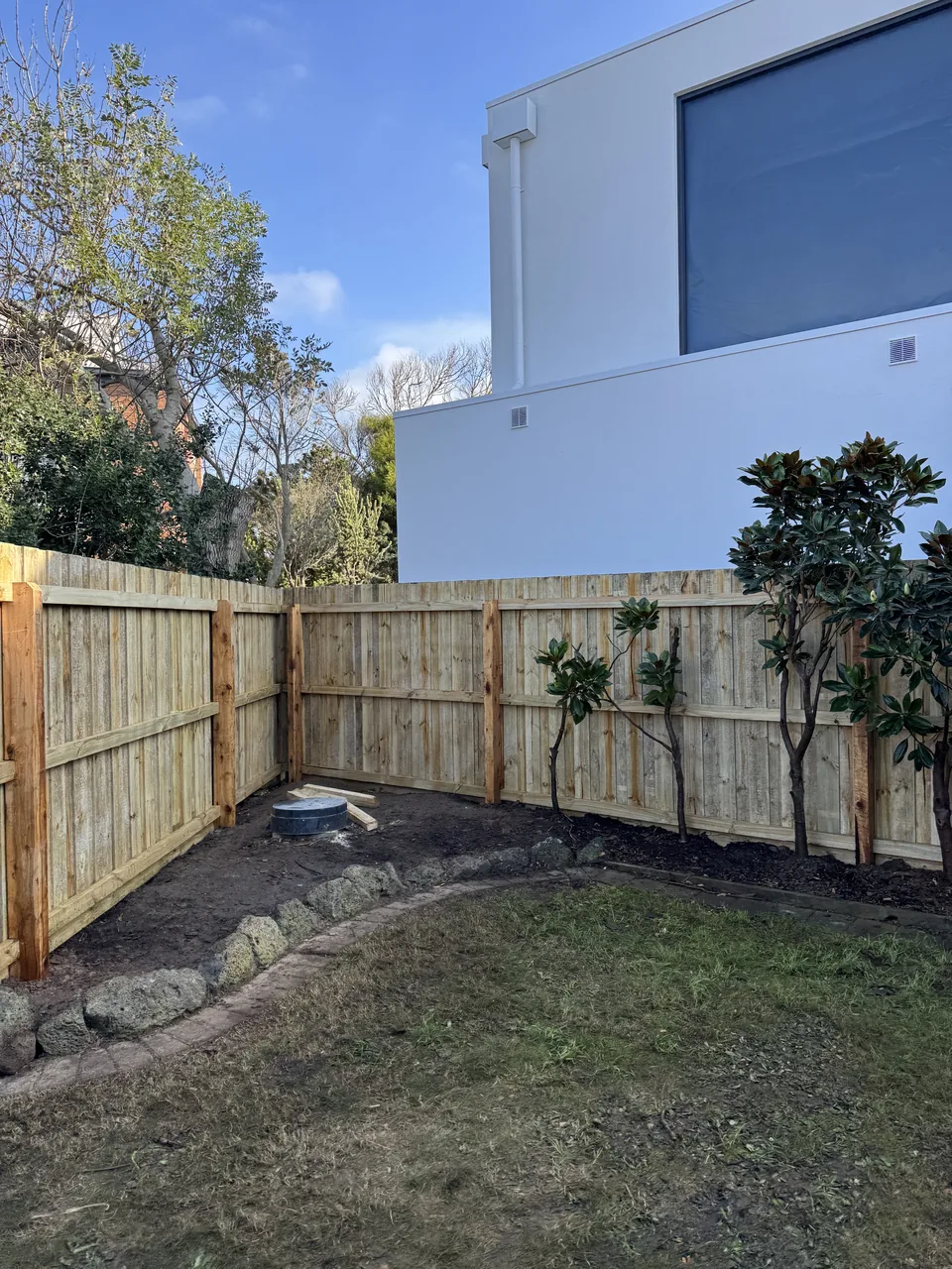 1.8 m timber paling fence around a garden, viewed from the rail side
